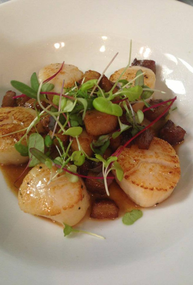 Seared scallops and pork belly with caramelized onions